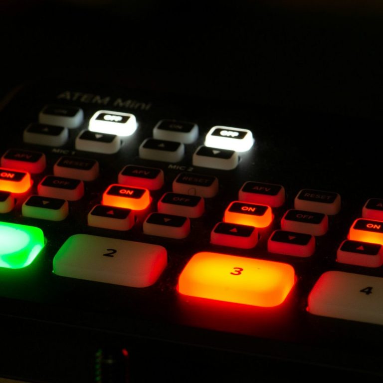 AV-Steuerung für Video- und Medientechnik bei Events Tastatur mit beleuchteten Tasten in verschiedenen Farben, darunter ein grüner und roter Knopf.